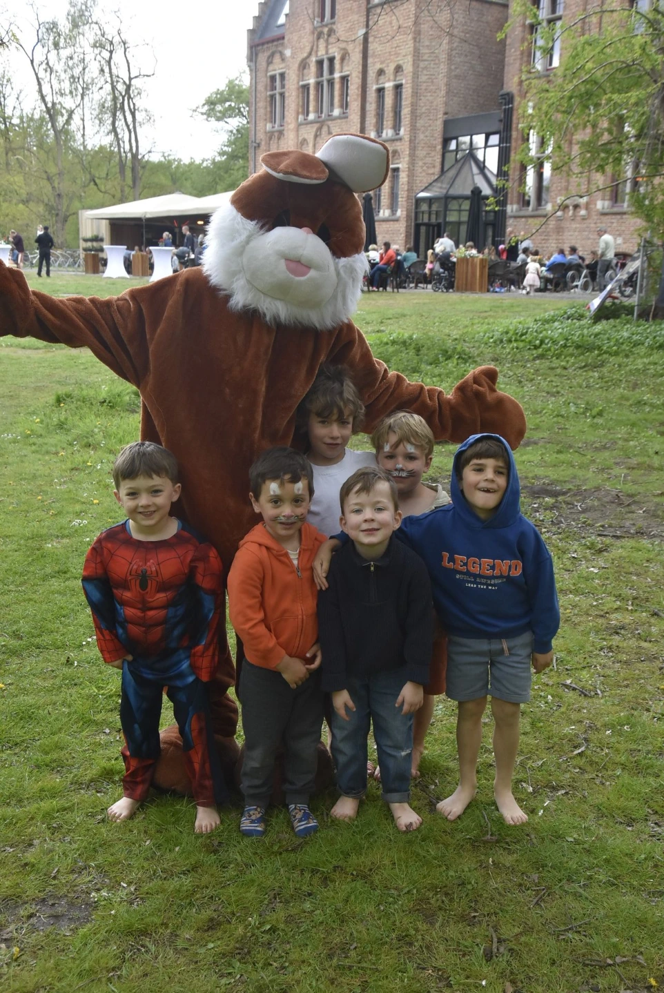 Bruine haas met kinderen: Een mascotte in een bruin hazenpak poseert met een groepje kinderen.
