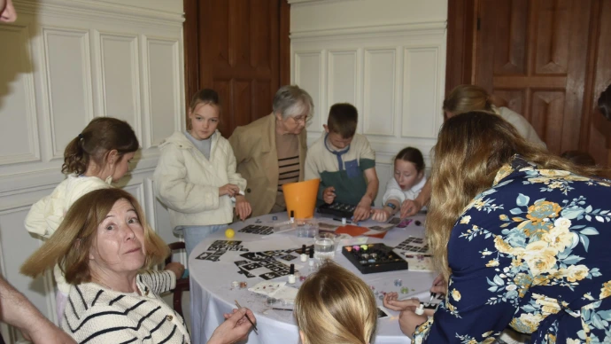 Kinderen aan tafel: Een groep kinderen zit rond een tafel tijdens een activiteit of feestje binnenshuis.